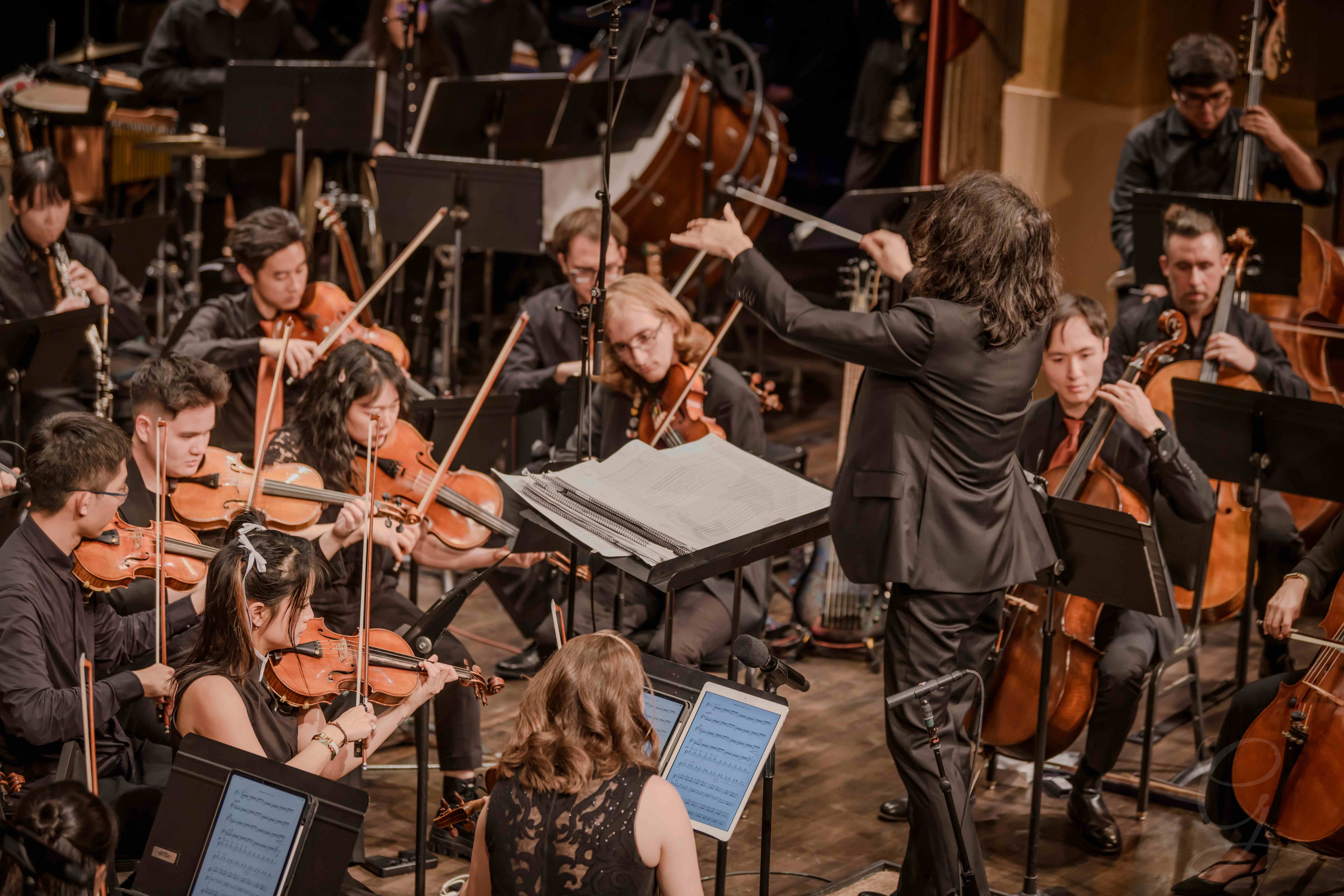 Conductor leading the GG Orchestra mid-performance seen from above
