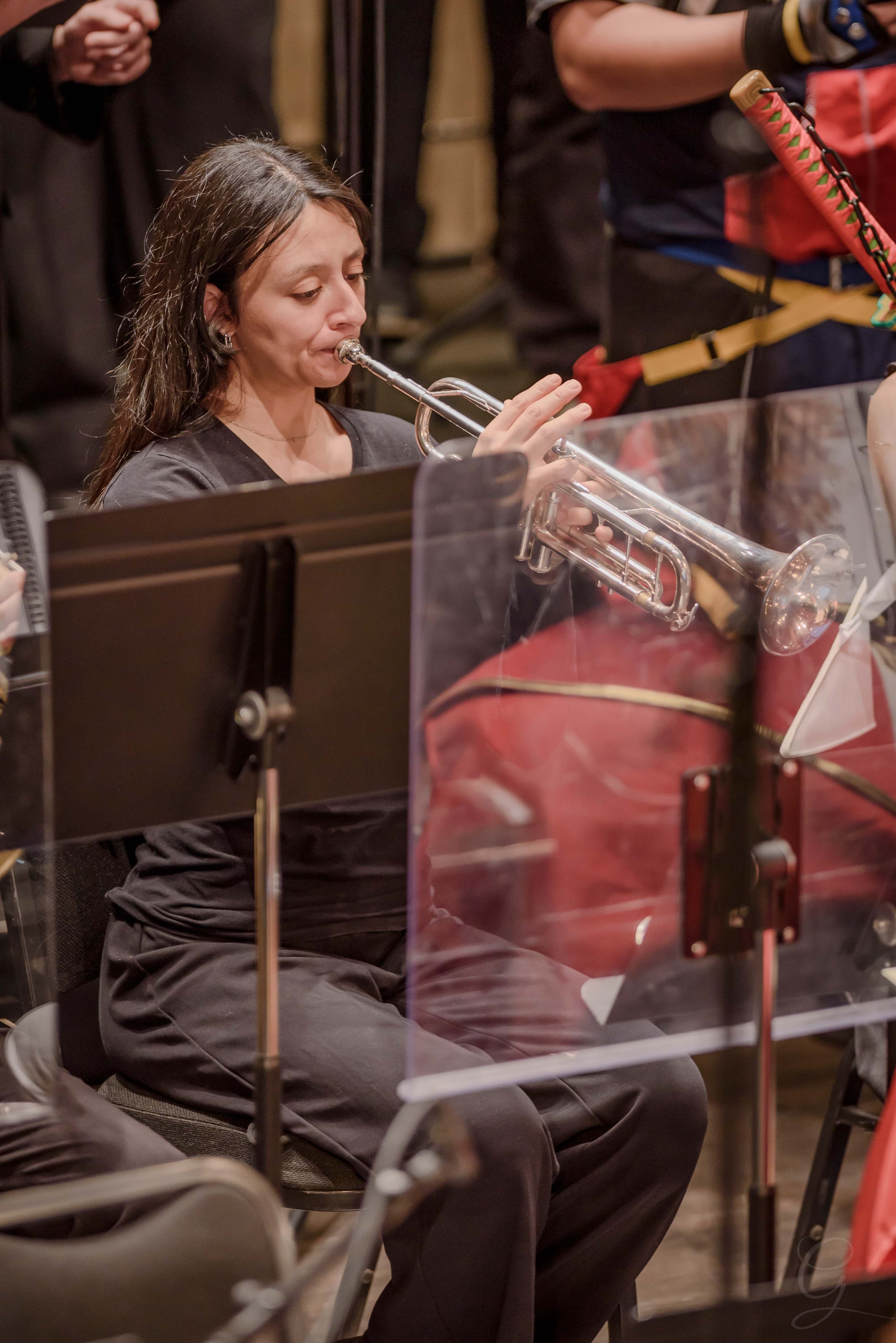 Trumpet player performing behind a shield during a GG Orchestra concert